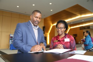Angela Hayes, district WIN Center Education Coordinator, looks on as Jimmie Coins, human resource specialist with Atmos Energy , signs up to recognize the ACT Work Ready Community effort Jan. 18 at the Jackson Convention Complex. (Hinds Community College/April Garon)