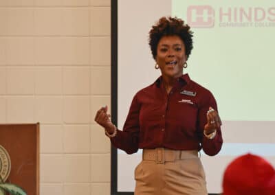 Young, energetic, black female speaking to students while gesturing with her hands